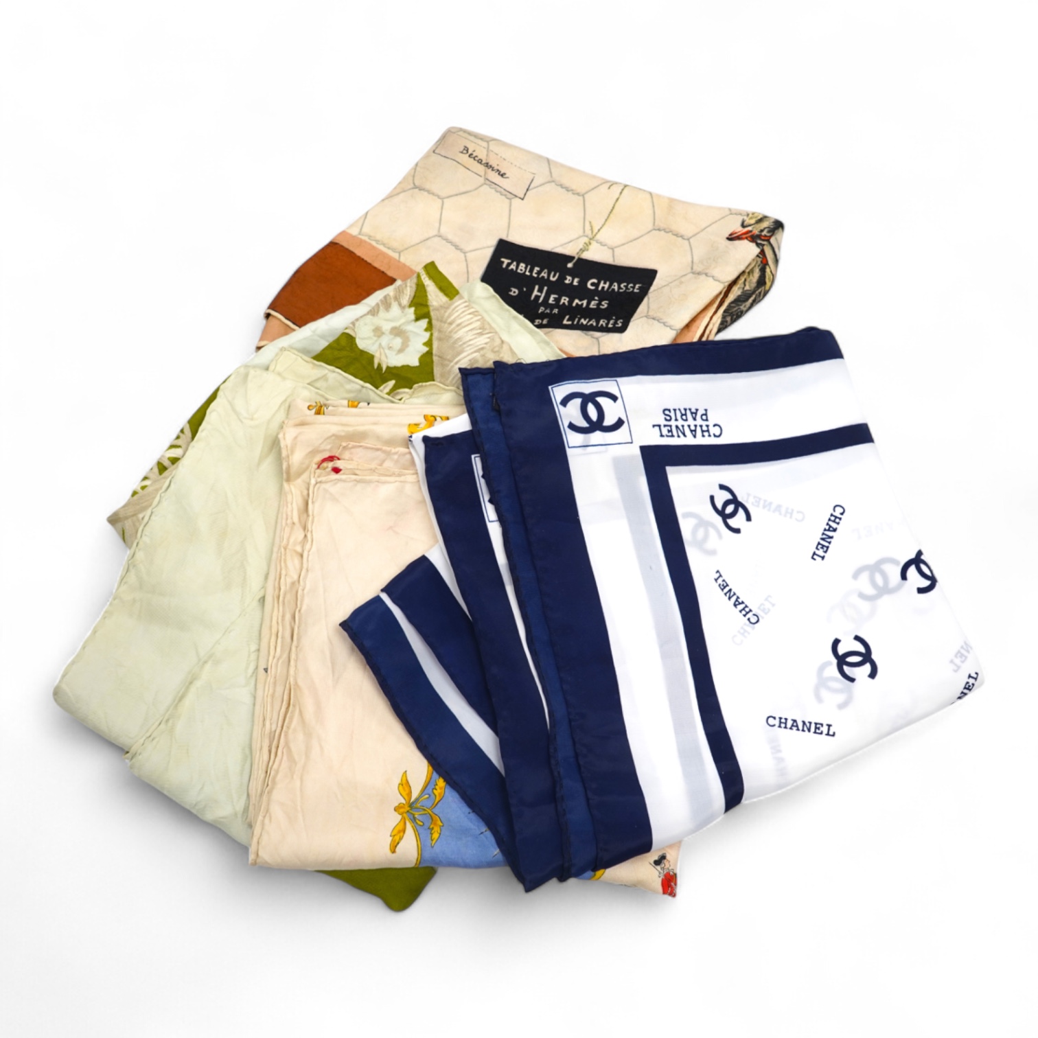 A collection of three Hermes silk scarves and a Chanel monogram example
